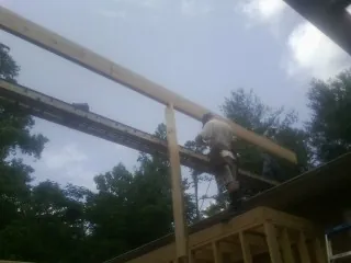 Carpenter setting a ridge beam over a new addition frame — Ice Dam Removal by Roofing Brothers in Rescue