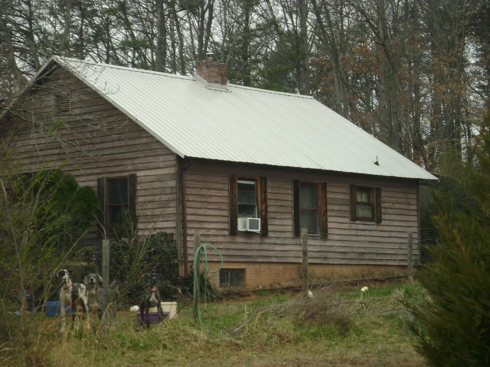 White metal roof on an old wood sided farmhouse, from a Metal Roof Installation job in Rescue